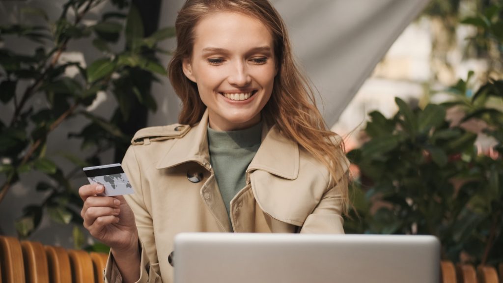 Young woman with credit card checking her bank account on laptop